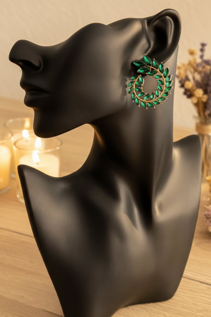 Gold hoop earrings wrapped with green and white boucle thread displayed on matte black bust.