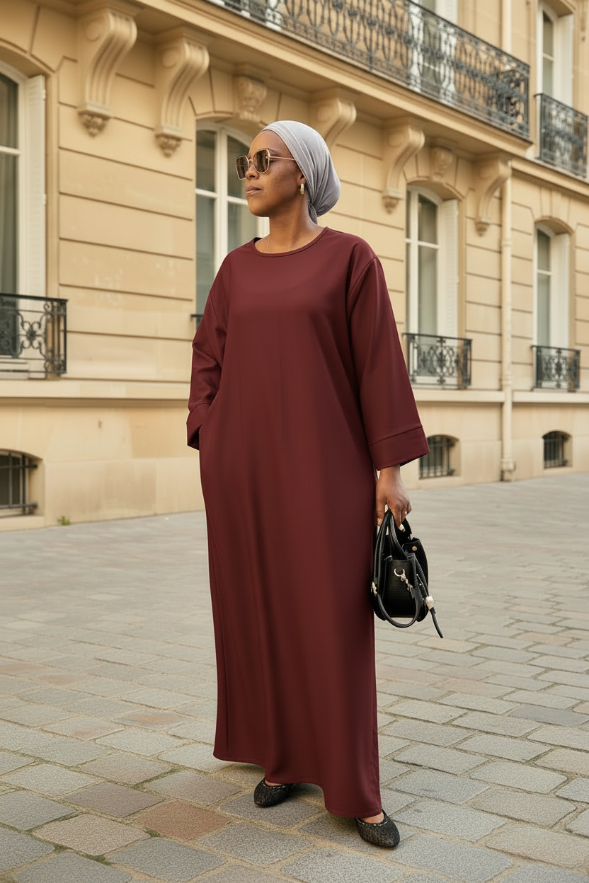 Abaya Mina rouge bordeaux – vue de face, portée dans une rue parisienne