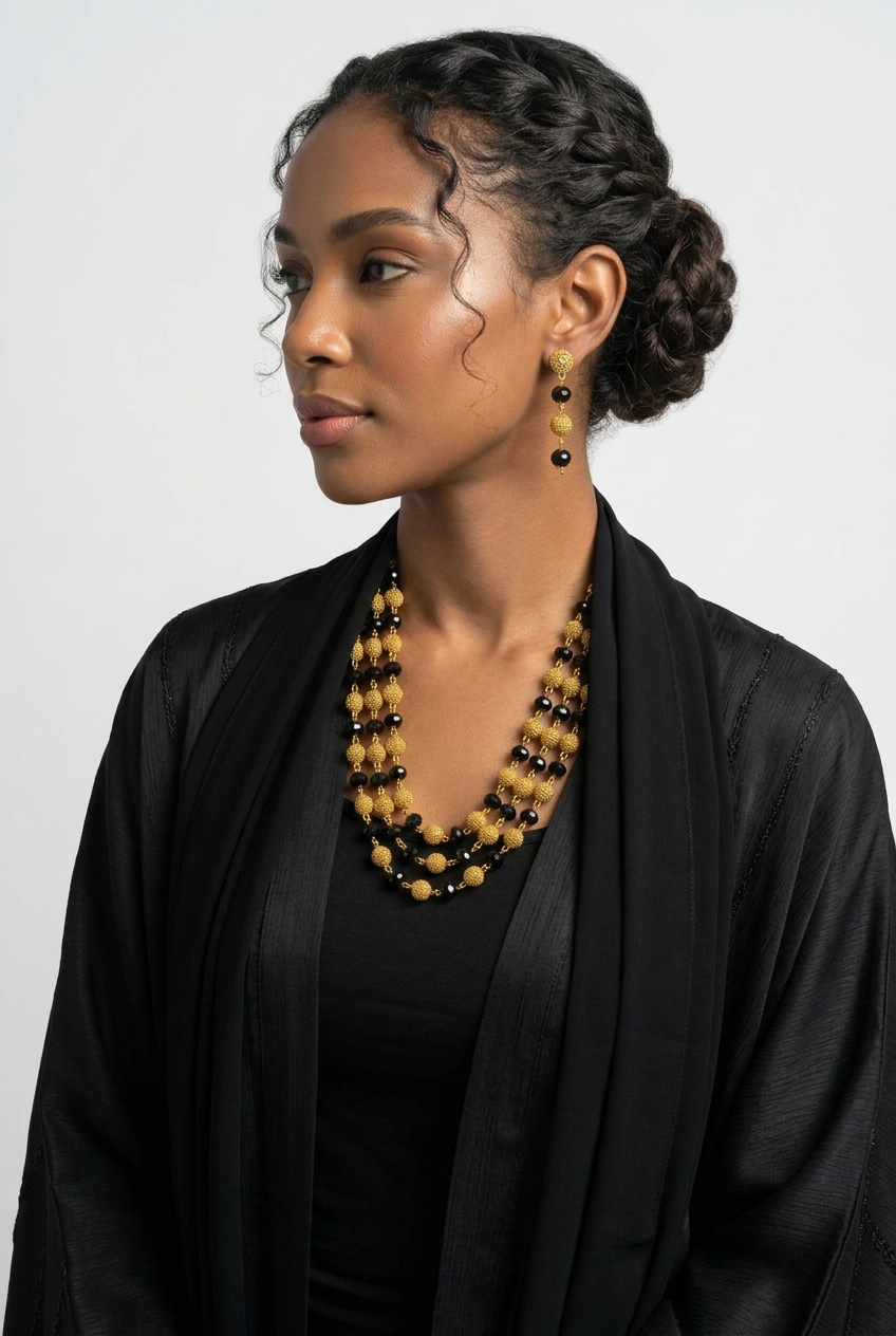 Parure Nadia plaqué or – détail du collier multi-rangs perles noires et dorées et boucles assorties