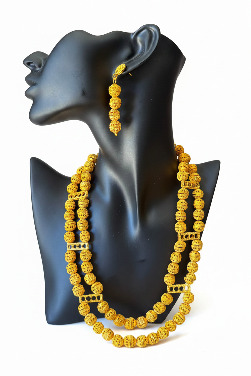 Parure Amara plaqué or portée par une femme : collier double rang et boucles d'oreilles perles filigranées